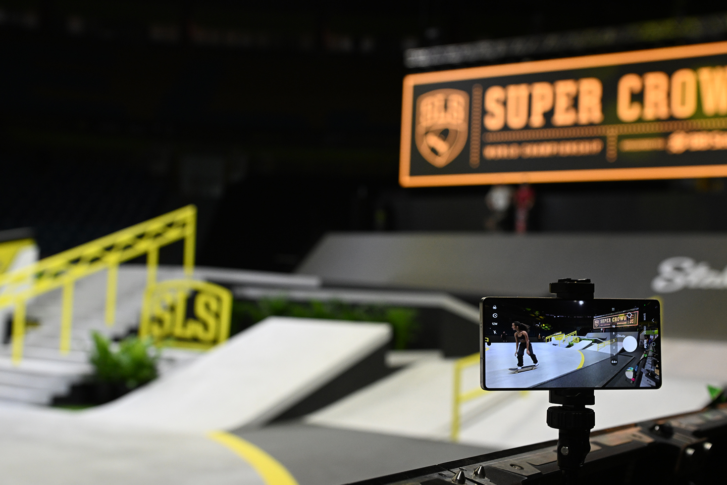 An image carousel features a Galaxy S25 mounted near the SLS Super Crown World Championship stage as it captures a skateboarder’s moves during a routine. 