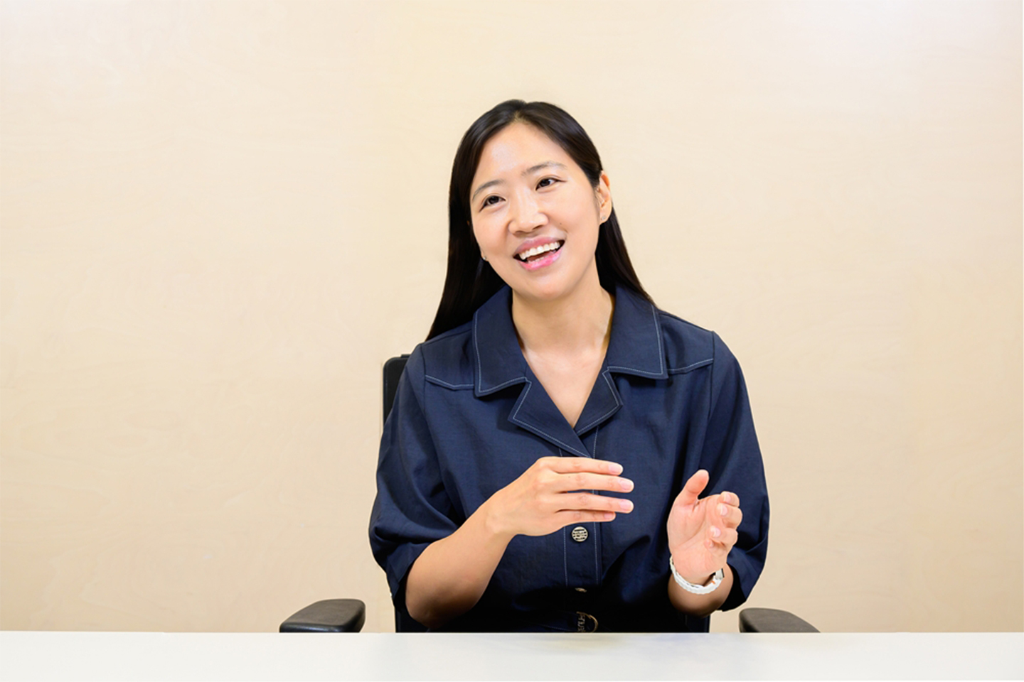The Samsung employee sits across a table. Her hand gestures indicate that she is talking.